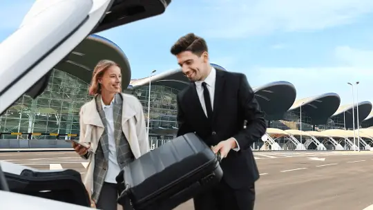Couple loading luggage into a car at Houari Boumediene Algiers airport.